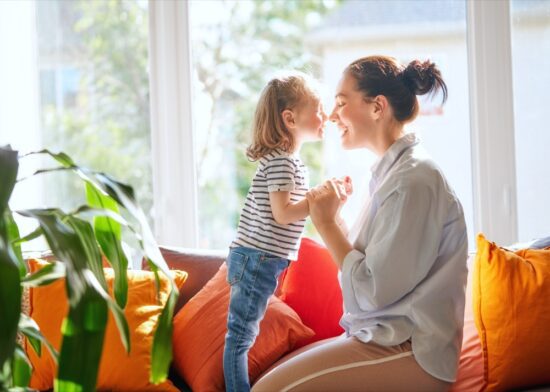 Happy mother's day! Mom and her daughter child girl are playing, smiling and hugging. Family holiday and togetherness.